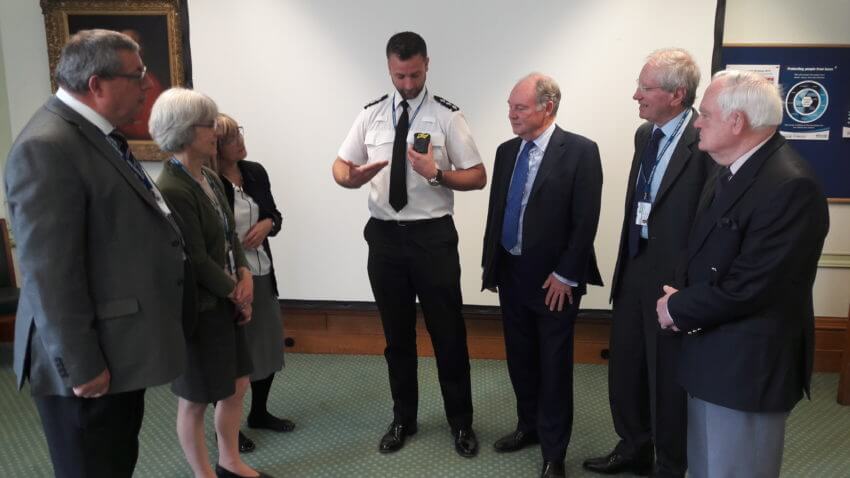 Chief Inspector Damian Pettit demonstrating the body worn video technology to members of the TIE Committee