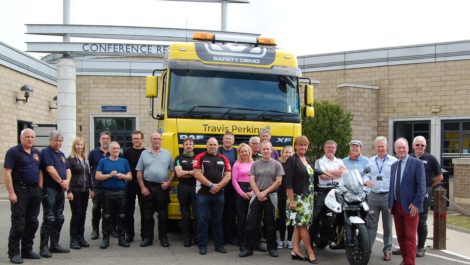 The class poses in front of a truck during the Rider Skills Day. Participants got the chance to climb into the cab to the limited visibility the driver would have of bikers.