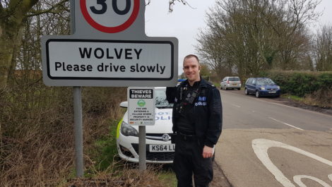 PC Stuart Baker from Warwickshire Police with the signage at the village entrance.