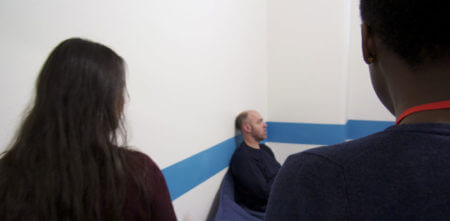 Two custody visitors in a cell with a detainee