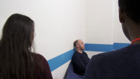 Two custody visitors in a cell with a detainee