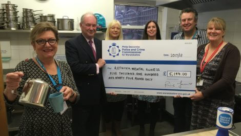 Warwickshire Police and Crime Commissioner Philip Seccombe presents a cheque for the funding to staff from Rethink Mental Illness during one of the drop-in coffee mornings at the centre in Warwick