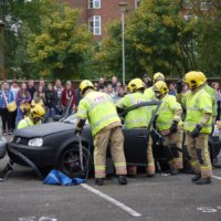 Fire officers at a mock collision demonstrate how they extract casualties from a crashed vehicle.