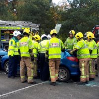Fire officers at a mock collision demonstrate how they extract casualties from a crashed vehicle.