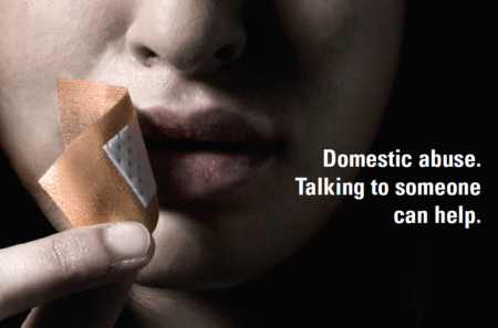 A woman peels a plaster from over her mouth. Caption reads 'Domestic abuse - Talking to someone can help'