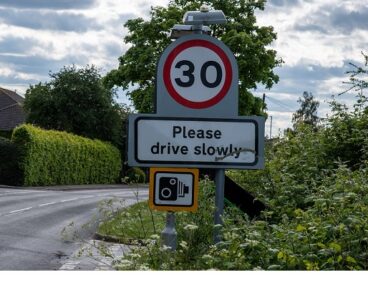 A road sign saying 'please drive slowly'