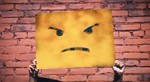 An angry face is held up on a banner