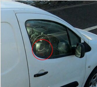 A van driver uses a phone while driving