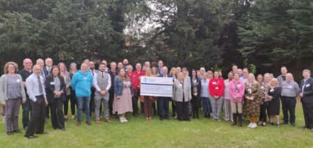 A large group of grants recpipients stand with the Commissioner and a giant cheque