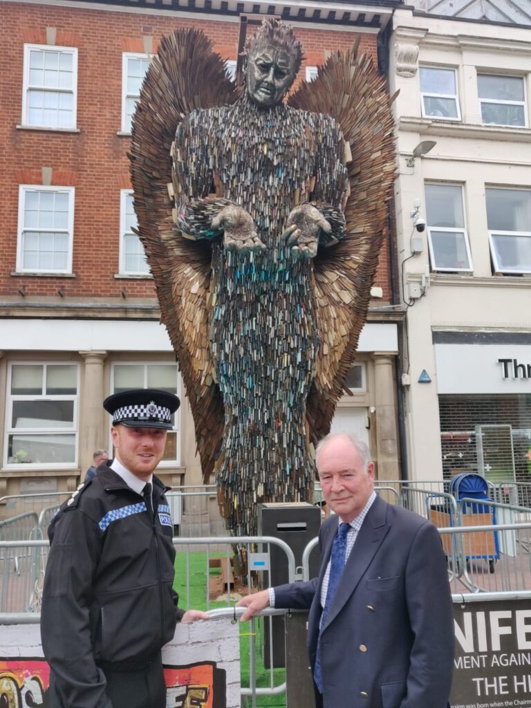 Two people stand in front of the Knife Angel